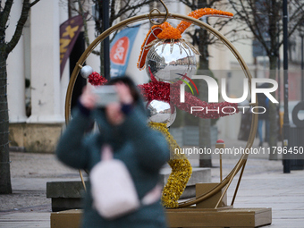 People walk past Christmas lights decoratoins prepared for the upcoming season in Warsaw, Poland on 18 November, 2024. Warsaw is an increasi...