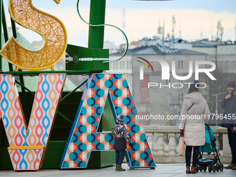 People walk past Christmas lights decoratoins prepared for the upcoming season in Warsaw, Poland on 18 November, 2024. Warsaw is an increasi...