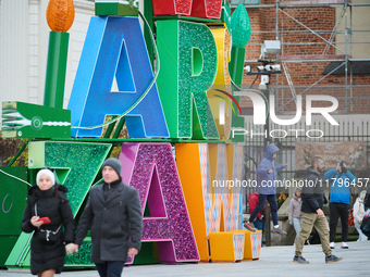 People walk past Christmas lights decoratoins prepared for the upcoming season in Warsaw, Poland on 18 November, 2024. Warsaw is an increasi...