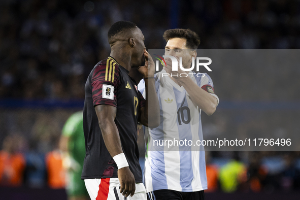 Luis Advincula of Peru and Lionel Messi of Argentina chat with their mouths covered during the South American qualifiers soccer match for th...