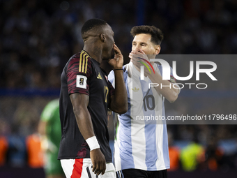 Luis Advincula of Peru and Lionel Messi of Argentina chat with their mouths covered during the South American qualifiers soccer match for th...