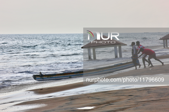 Fishermen push a fishing boat into the ocean along Paruthiyoor Beach in Paruthiyoor, Kerala, India, on April 15, 2024. 