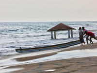 Fishermen push a fishing boat into the ocean along Paruthiyoor Beach in Paruthiyoor, Kerala, India, on April 15, 2024. (