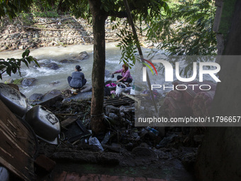 Residents clean their homes and try to save the remaining belongings after a flash flood hits Mekarbuana village, Karawang district, West Ja...