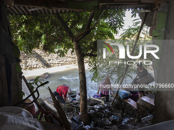 Residents clean their homes and try to save the remaining belongings after a flash flood hits Mekarbuana village, Karawang district, West Ja...