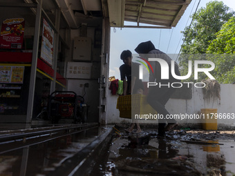 Residents clean their homes and try to save the remaining belongings after a flash flood hits Mekarbuana village, Karawang district, West Ja...