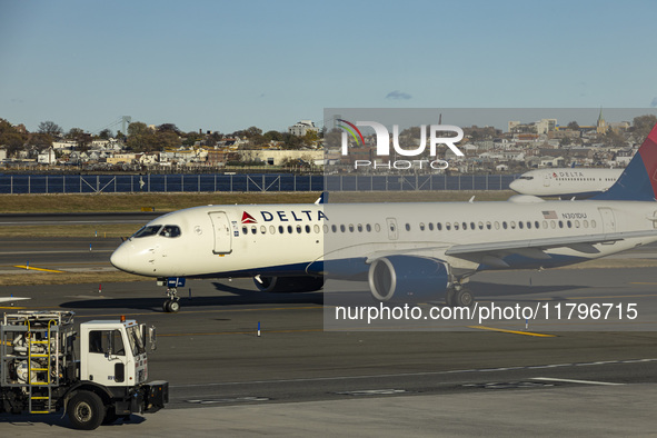 Delta Air Lines Airbus A220-300 passenger aircraft spotted taxiing on the runway and taxiway of LaGuardia airport in NYC with a Boeing 737 o...