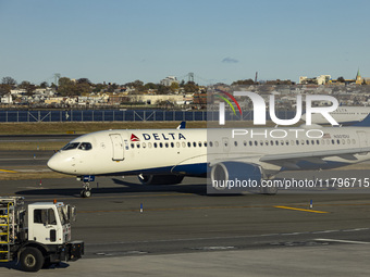 Delta Air Lines Airbus A220-300 passenger aircraft spotted taxiing on the runway and taxiway of LaGuardia airport in NYC with a Boeing 737 o...