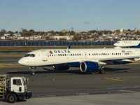 Delta Air Lines Airbus A220-300 passenger aircraft spotted taxiing on the runway and taxiway of LaGuardia airport in NYC with a Boeing 737 o...