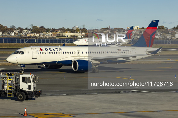 Delta Air Lines Airbus A220-300 passenger aircraft spotted taxiing on the runway and taxiway of LaGuardia airport in NYC with a Boeing 737 o...