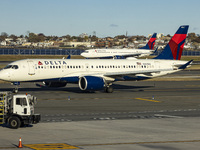 Delta Air Lines Airbus A220-300 passenger aircraft spotted taxiing on the runway and taxiway of LaGuardia airport in NYC with a Boeing 737 o...