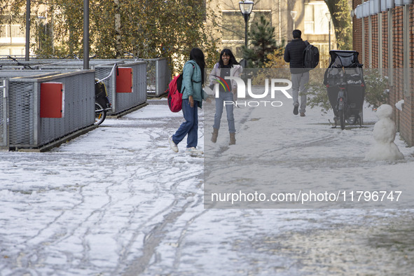 Kids play with the snow after building a snowman. First winter weather of the season with snow hit the Netherlands. Low temperatures with we...