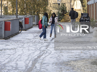 Kids play with the snow after building a snowman. First winter weather of the season with snow hit the Netherlands. Low temperatures with we...