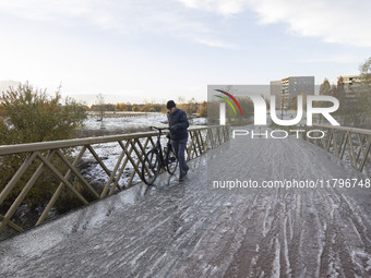 People spotted on their bicycle during with the snow around them. First winter weather of the season with snow hit the Netherlands. Low temp...