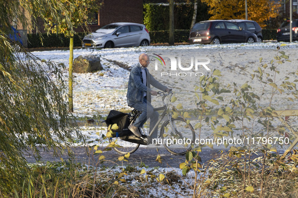 People spotted on their bicycle during with the snow around them. First winter weather of the season with snow hit the Netherlands. Low temp...