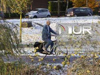 People spotted on their bicycle during with the snow around them. First winter weather of the season with snow hit the Netherlands. Low temp...