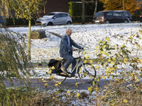 People spotted on their bicycle during with the snow around them. First winter weather of the season with snow hit the Netherlands. Low temp...