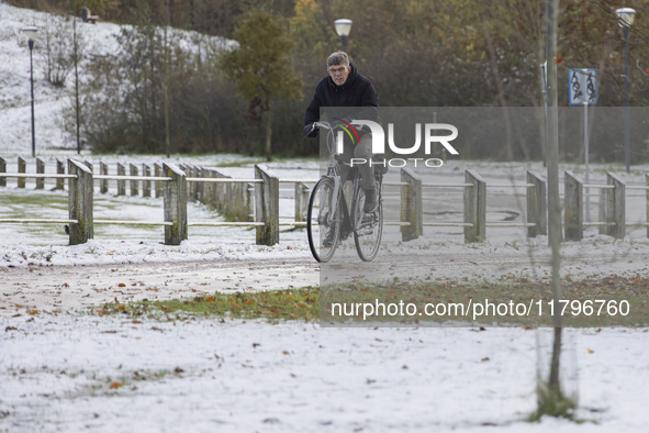 People spotted on their bicycle during with the snow around them. First winter weather of the season with snow hit the Netherlands. Low temp...