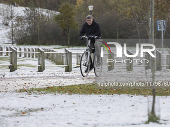 People spotted on their bicycle during with the snow around them. First winter weather of the season with snow hit the Netherlands. Low temp...