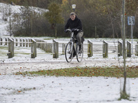 People spotted on their bicycle during with the snow around them. First winter weather of the season with snow hit the Netherlands. Low temp...