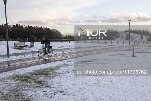 People spotted on their bicycle during with the snow around them. First winter weather of the season with snow hit the Netherlands. Low temp...