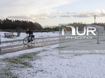 People spotted on their bicycle during with the snow around them. First winter weather of the season with snow hit the Netherlands. Low temp...