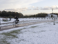 People spotted on their bicycle during with the snow around them. First winter weather of the season with snow hit the Netherlands. Low temp...