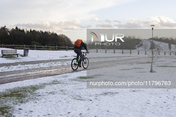 People spotted on their bicycle during with the snow around them. First winter weather of the season with snow hit the Netherlands. Low temp...