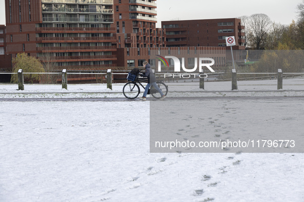  A kid is carrying his bicycle. First winter weather of the season with snow hit the Netherlands. Low temperatures with wet snow conditions...