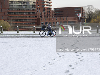  A kid is carrying his bicycle. First winter weather of the season with snow hit the Netherlands. Low temperatures with wet snow conditions...