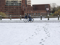  A kid is carrying his bicycle. First winter weather of the season with snow hit the Netherlands. Low temperatures with wet snow conditions...