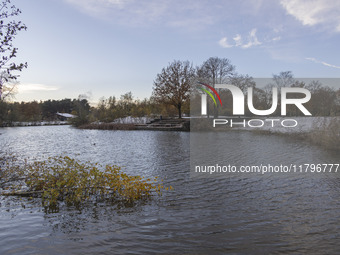 The lake and a wooden building in front of the forest in Park Meerland. First winter weather of the season with snow hit the Netherlands. Lo...