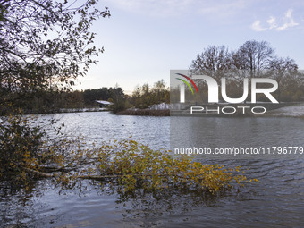 The lake and a wooden building in front of the forest in Park Meerland. First winter weather of the season with snow hit the Netherlands. Lo...