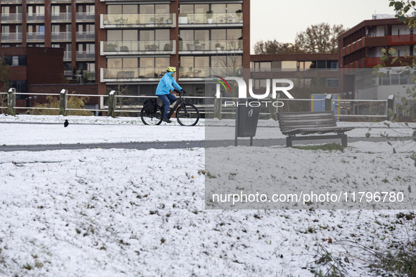 People spotted on their bicycle during with the snow around them. First winter weather of the season with snow hit the Netherlands. Low temp...