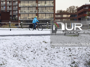 People spotted on their bicycle during with the snow around them. First winter weather of the season with snow hit the Netherlands. Low temp...