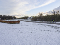 People spotted on their bicycle during with the snow around them. First winter weather of the season with snow hit the Netherlands. Low temp...