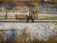 A woman is walking on the road carrying groceries. First winter weather of the season with snow hit the Netherlands as spotted before the su...