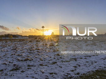 Cows spotted in a fenced area in the snow. First winter weather of the season with snow hit the Netherlands as spotted before the sunset. Lo...