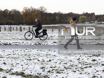 People spotted on their bicycle during with the snow around them. First winter weather of the season with snow hit the Netherlands. Low temp...