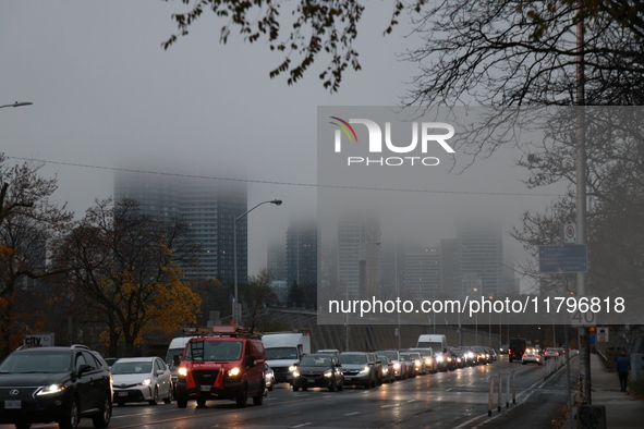 Vehicles make their way along Bloor Street East in foggy weather in Toronto, Ontario, on November 20, 2024. 