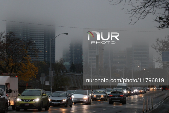 Vehicles make their way along Bloor Street East in foggy weather in Toronto, Ontario, on November 20, 2024. 