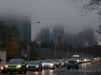 Vehicles make their way along Bloor Street East in foggy weather in Toronto, Ontario, on November 20, 2024. (