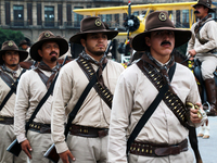 Members of the Mexican armed forces, dressed in attire from the era of the Mexican Revolution, pose before the parade for the 114th annivers...