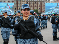 A woman from the Mexican armed forces poses before the parade for the 114th anniversary of the Mexican Revolution at the Zocalo capital in M...