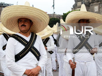 Members of the Mexican armed forces, dressed in attire from the era of the Mexican Revolution, pose before the parade for the 114th annivers...