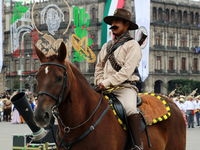 A member of the Mexican armed forces, dressed in attire from the time of the Mexican Revolution and riding a horse, is seen before the parad...