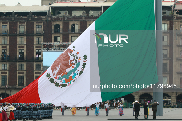 The Mexican flag is raised before the civic parade for the 114th anniversary of the Mexican Revolution at the Zocalo in Mexico City, Mexico,...