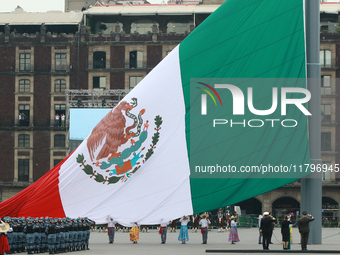 The Mexican flag is raised before the civic parade for the 114th anniversary of the Mexican Revolution at the Zocalo in Mexico City, Mexico,...