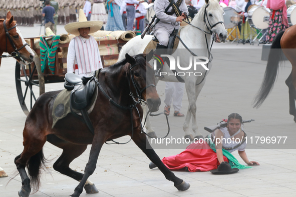 A female rider dressed as a Mexican Revolutionary woman and her horse have an accident during the parade marking the 114th anniversary of th...