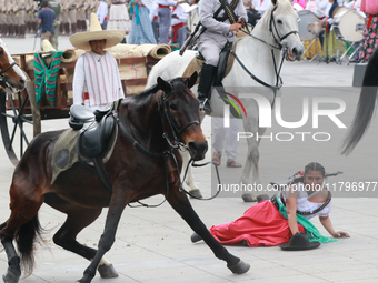 A female rider dressed as a Mexican Revolutionary woman and her horse have an accident during the parade marking the 114th anniversary of th...